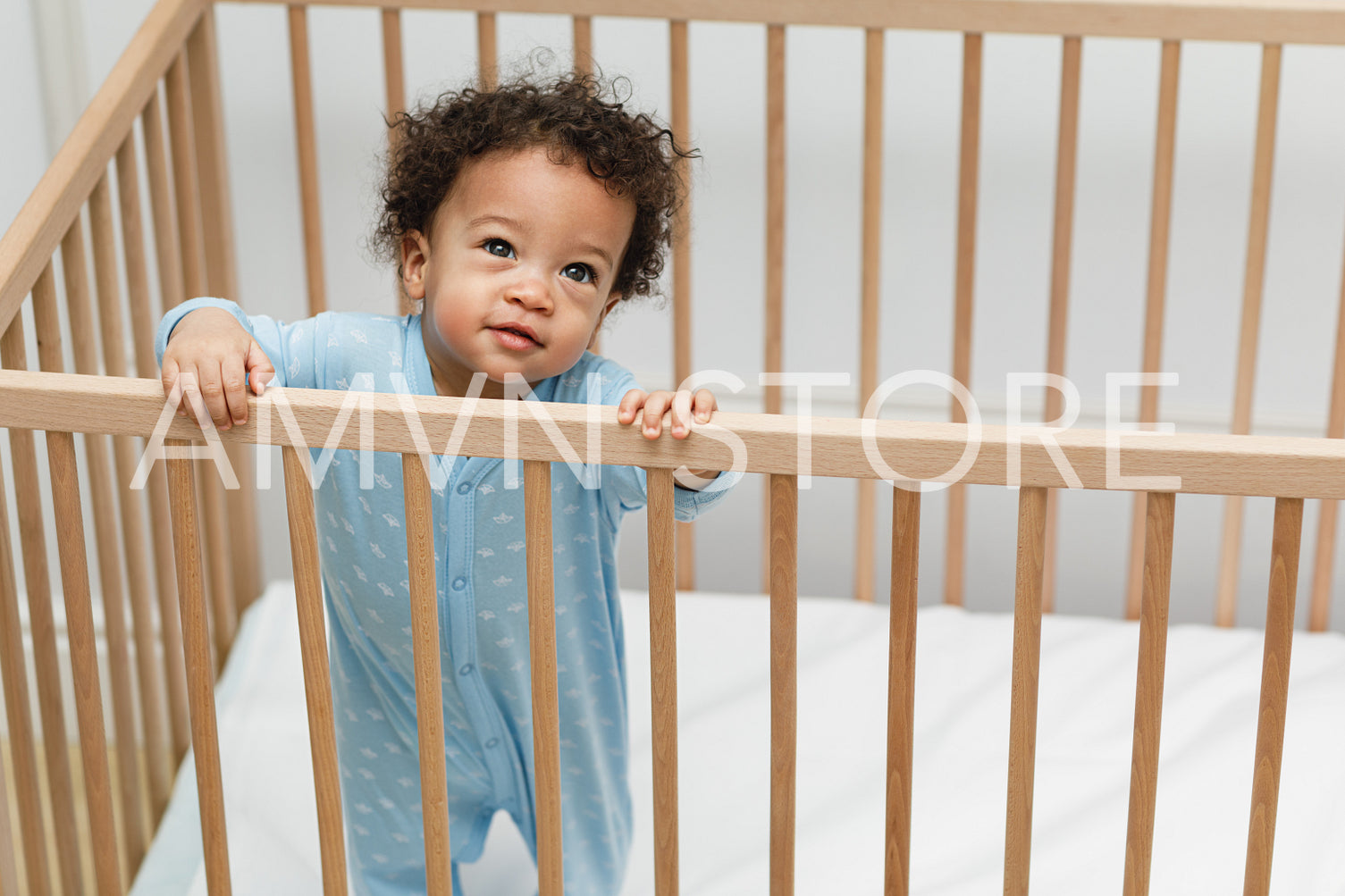 High angle portrait of cute baby boy standing in crib at home	