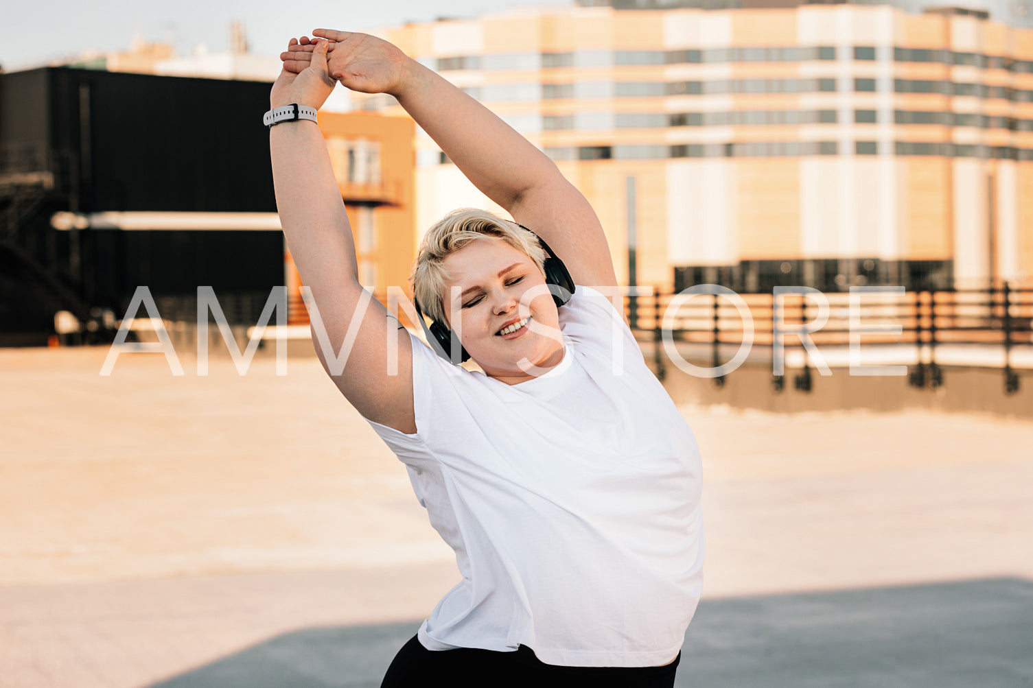 Happy woman with plus size body doing warming up exercises before workout