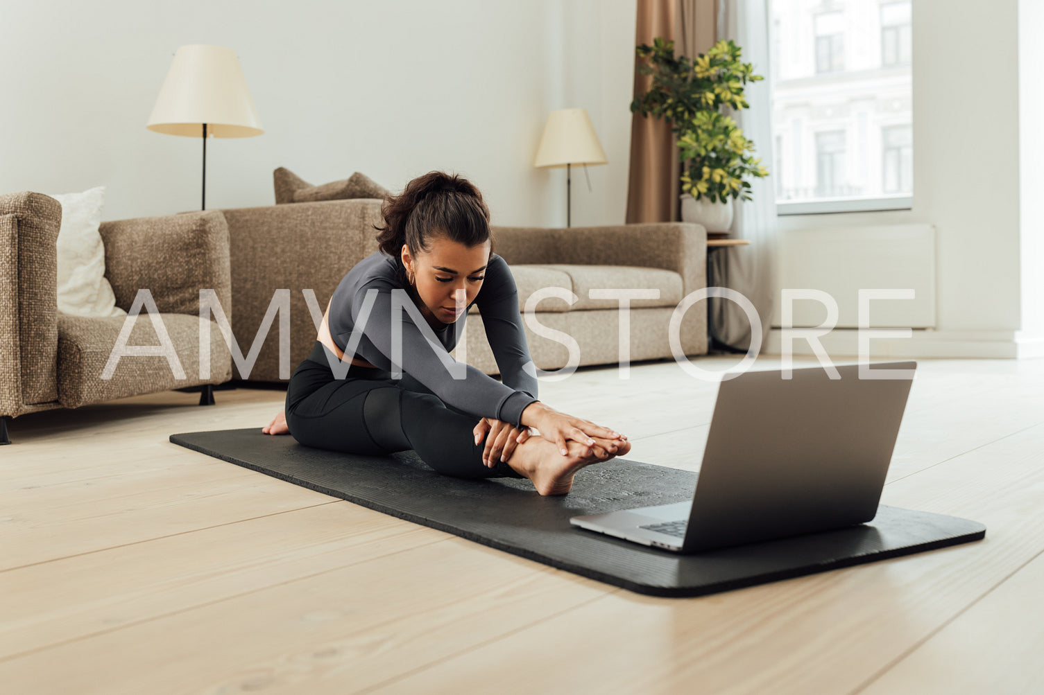 Mixed race woman repeating exercises from fitness instructor online	