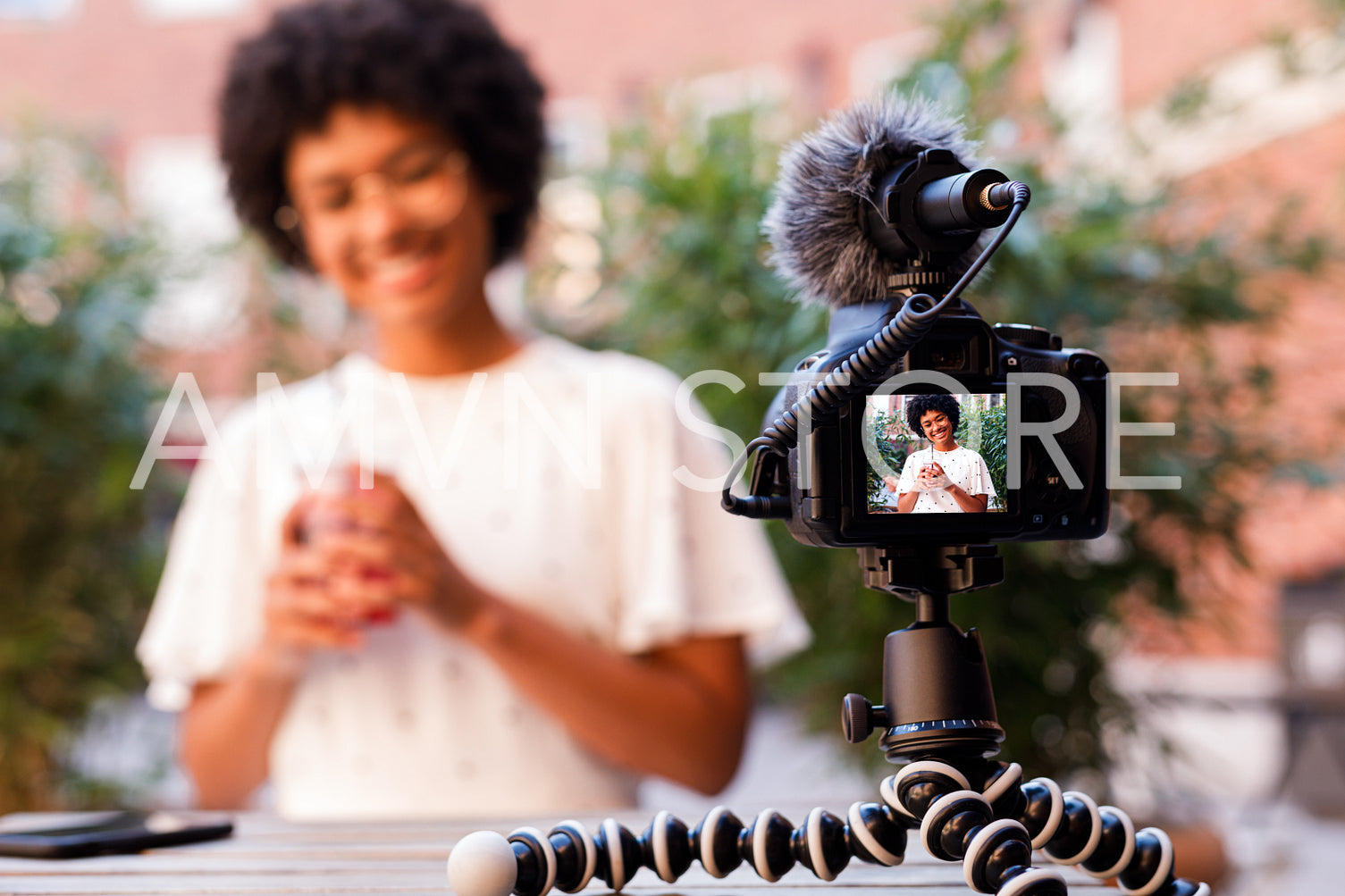 Woman recording a video content while sitting in outdoor cafe	