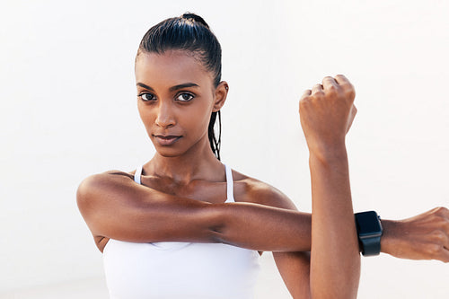 Portrait of a professional athlete warming up her hands. Fitness influencer flexing her hands and looking at camera.