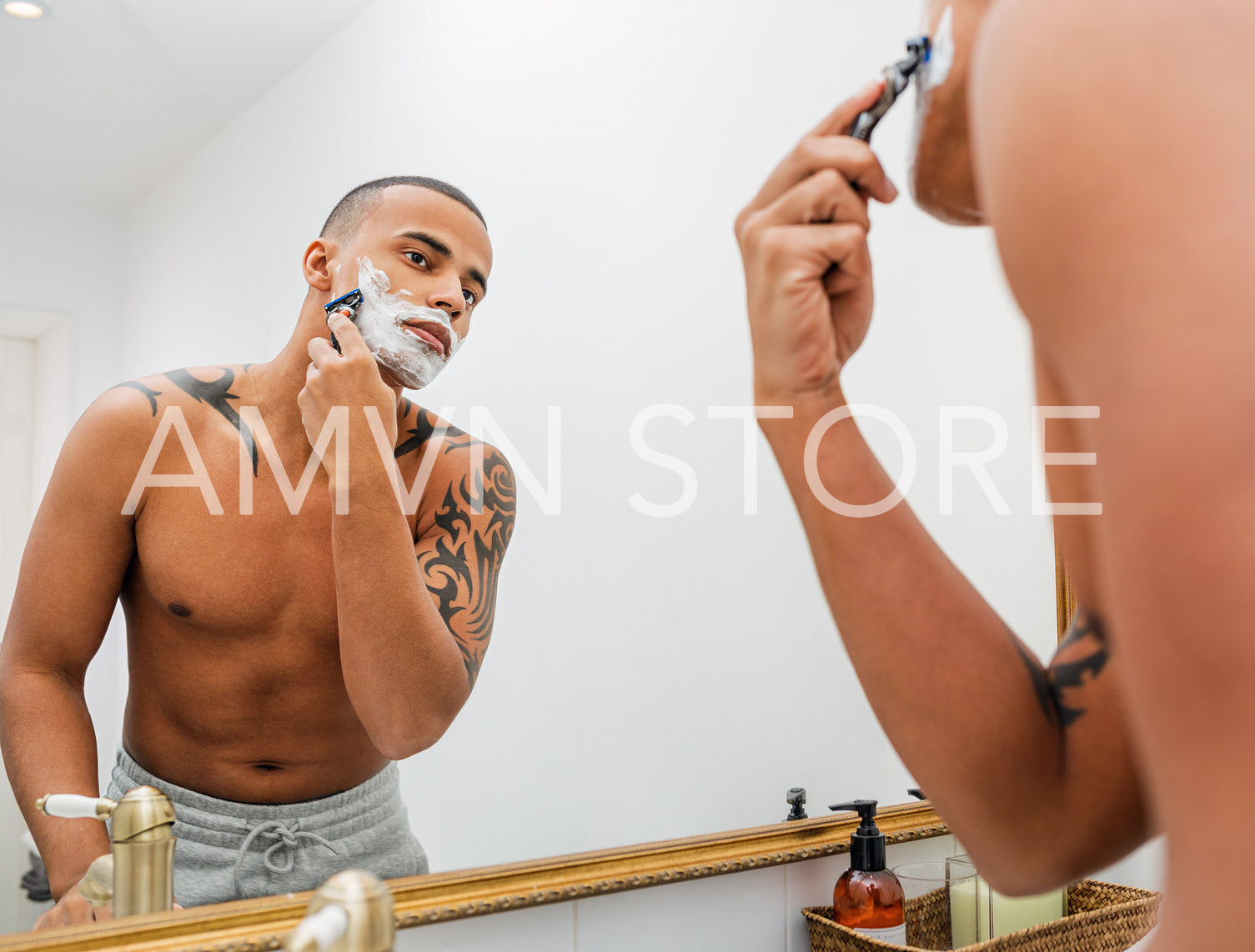 Portrait of a handsome young man shaving his facial hair in the bathroom	