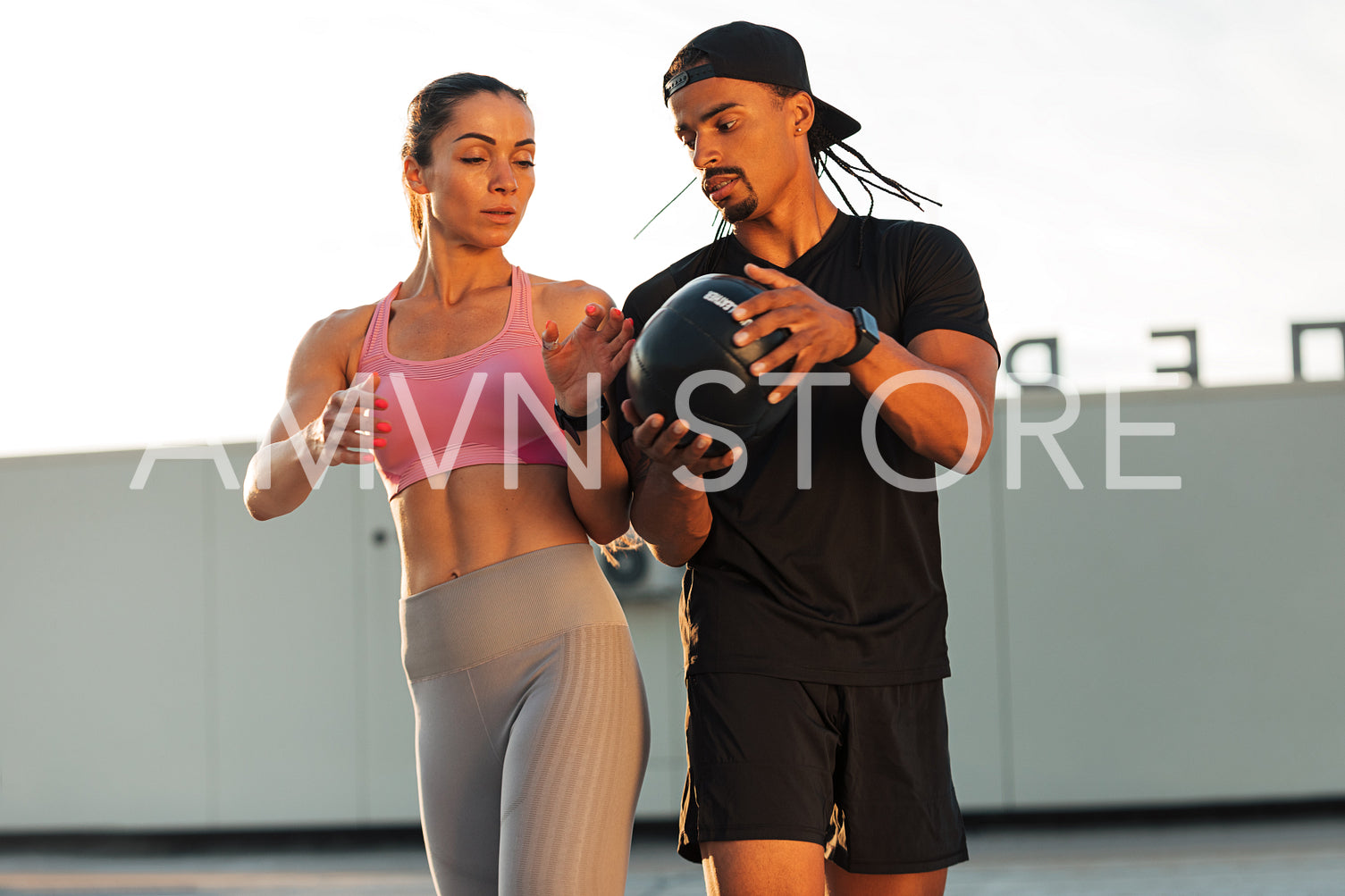 Man and woman exercising with a medicine ball on roof