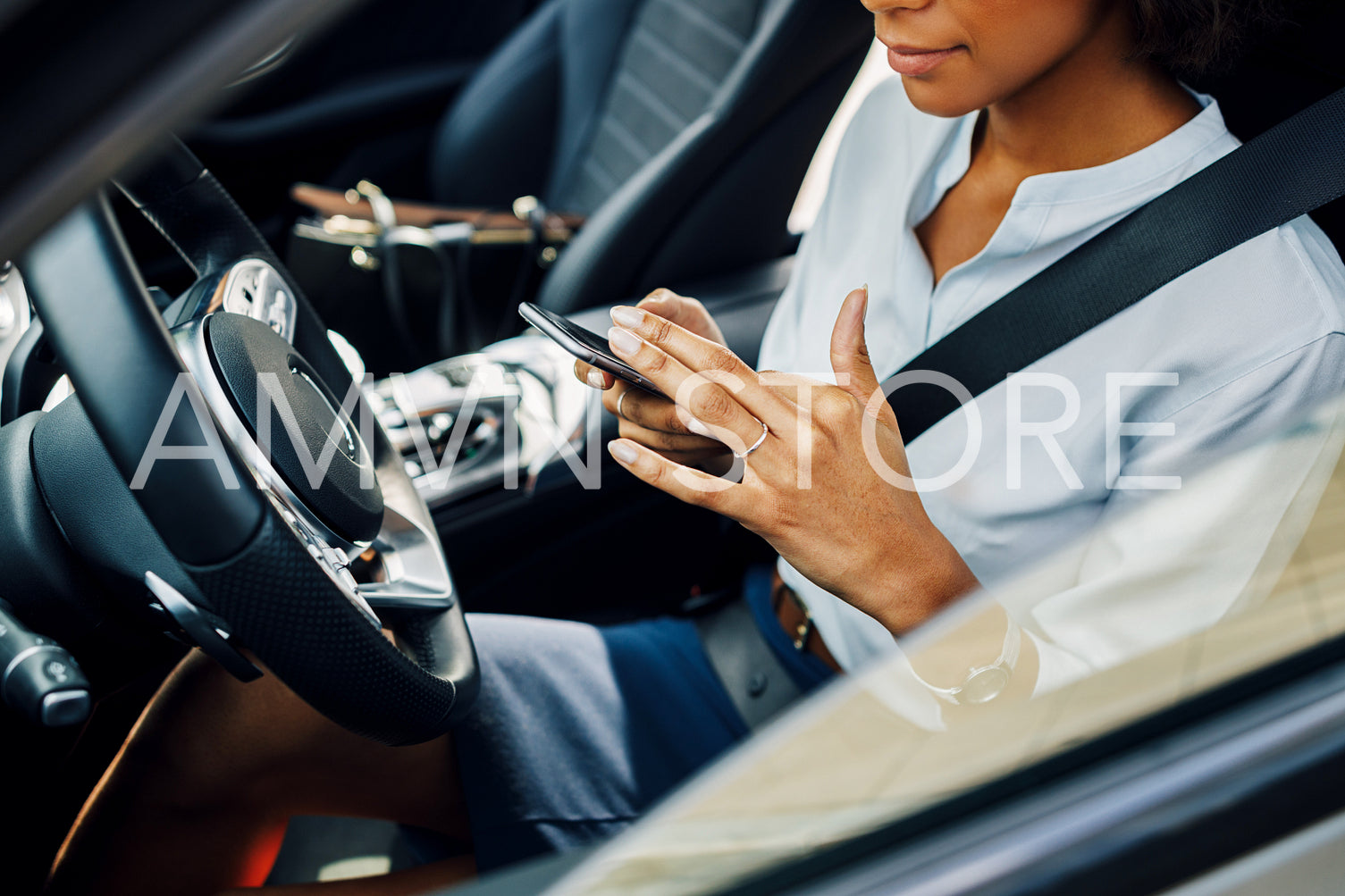 Unrecognizable woman using smartphone while sitting in car.	