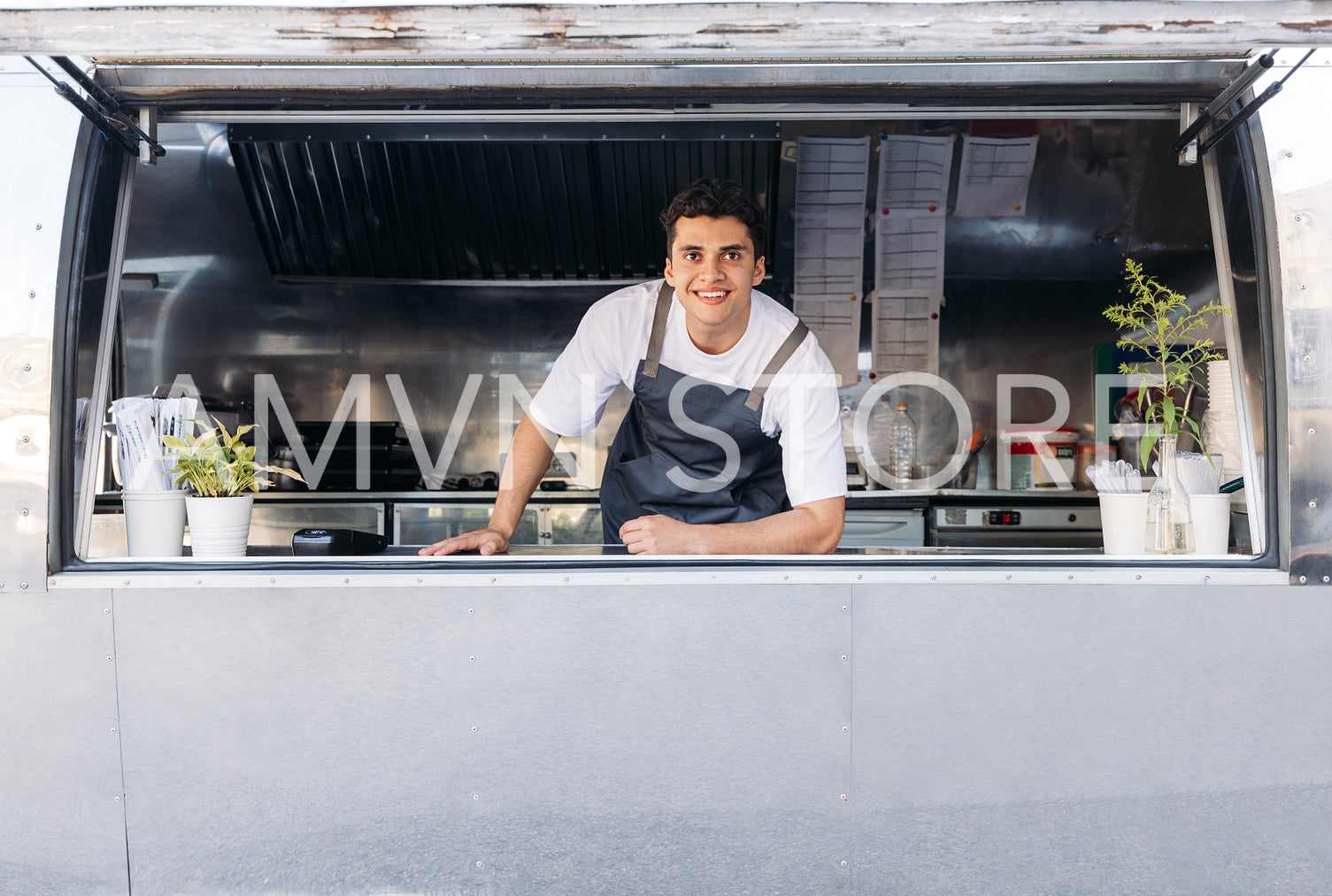 Portrait of a young food truck owner. Food truck owner waiting for customers.