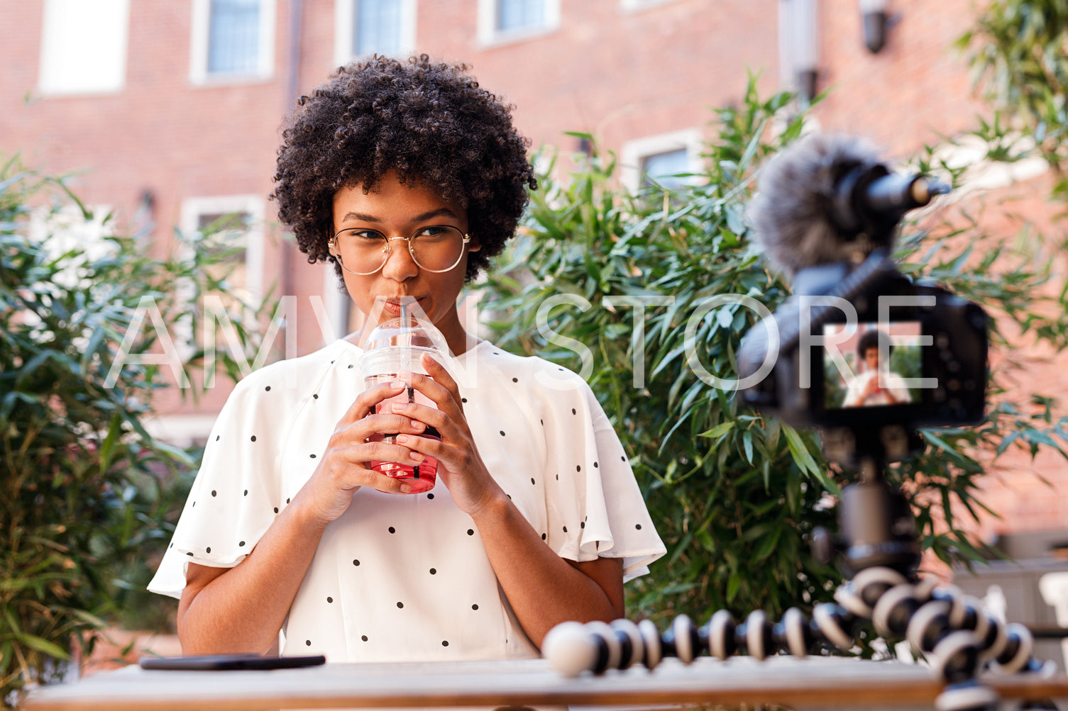 Girl drinking juice while making content for video blog	