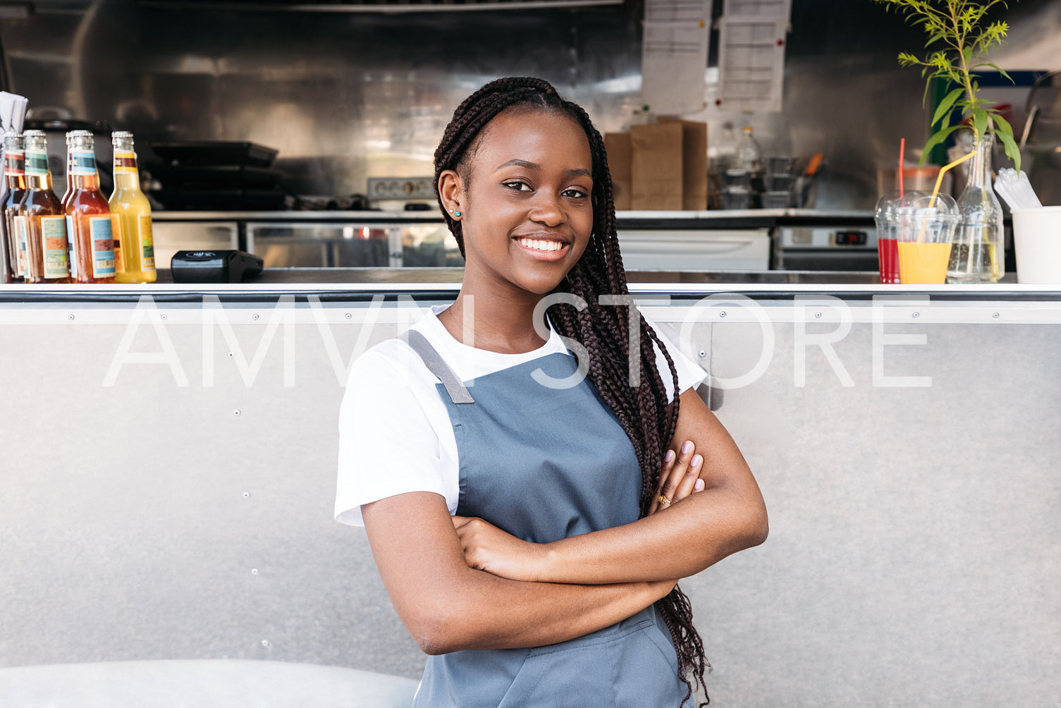 Portrait of a confident waitress with long braids standing at food truck