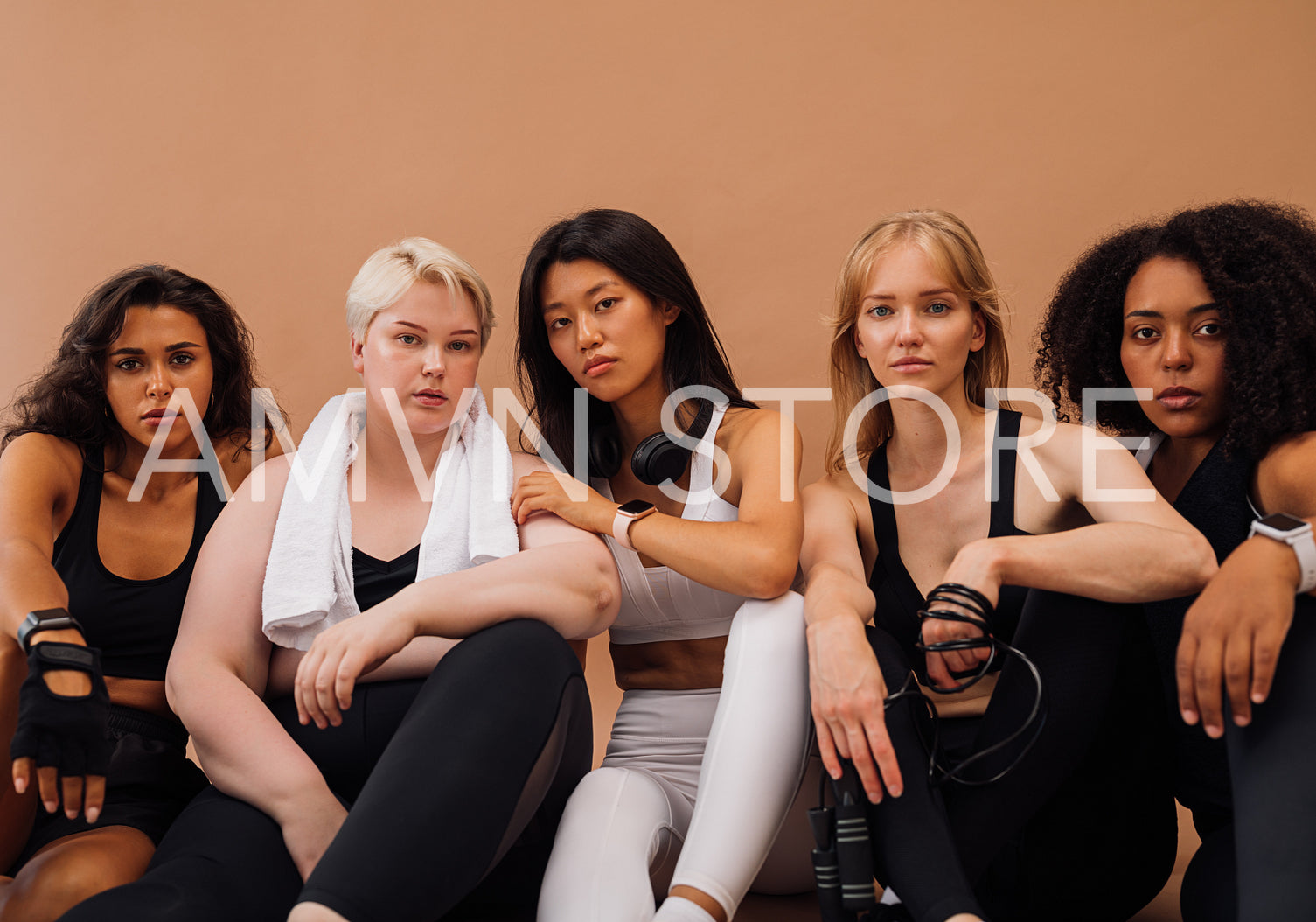 Five confident females in sportswear with fitness accessories. Group of young sports women of different ethnicities looking at camera.