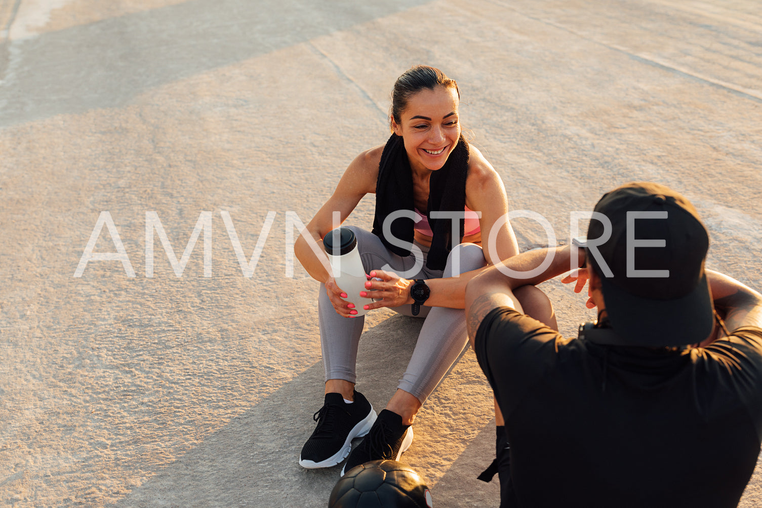 Smiling sportswoman looking at her fitness buddy while they are taking a break 