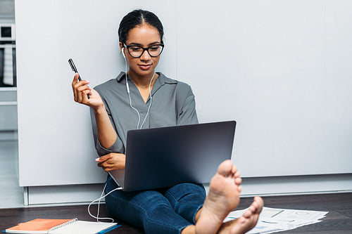 Businesswoman holding a pencil and looking on laptop screen during online meeting