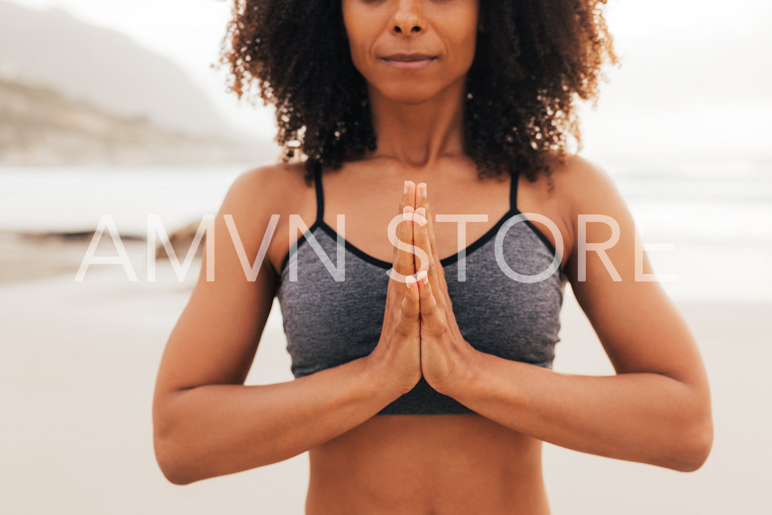 Close up of a hands of a woman meditating outdoors at sunset. Unrecognizable female with joined hands.