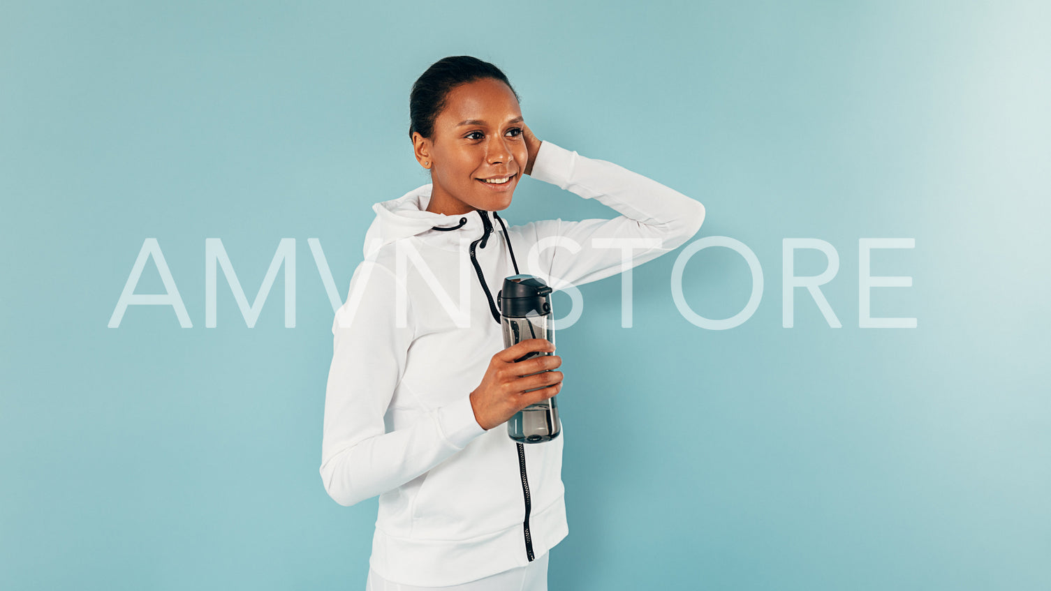 Young smiling woman posing in studio with a bottle of water	