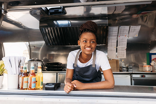 Portrait of young small business owner standing in her food truck waiting for clients