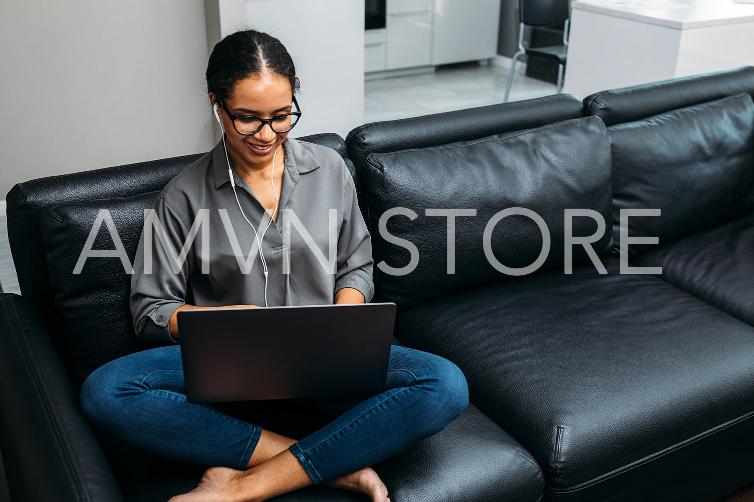 Smiling woman wearing earphones and working on laptop	