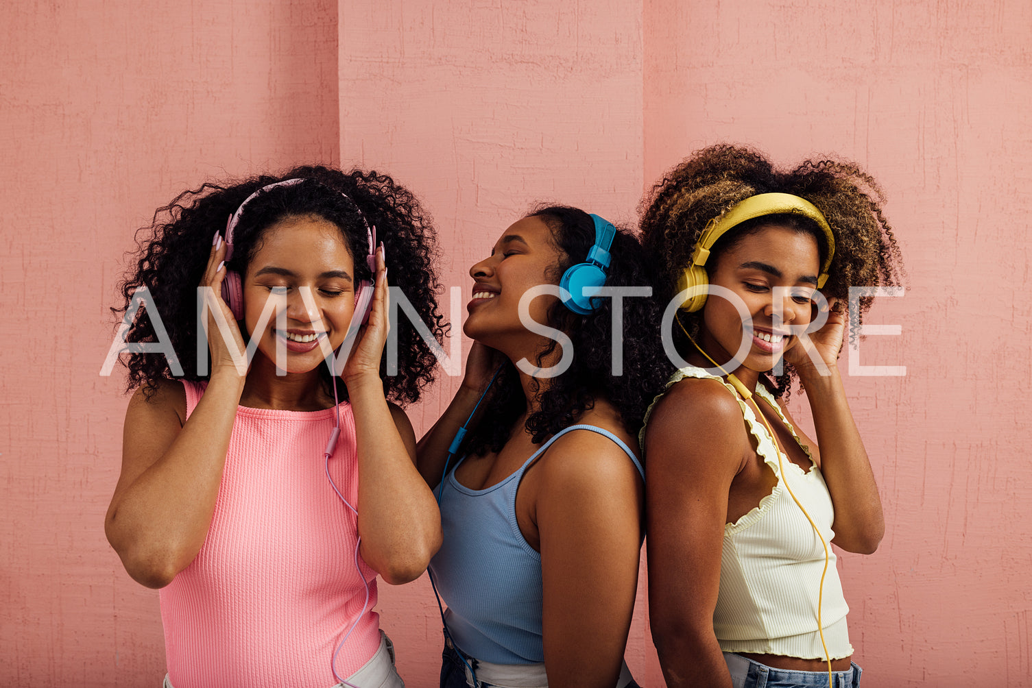 Group of female friends in casuals wearing headphones standing t