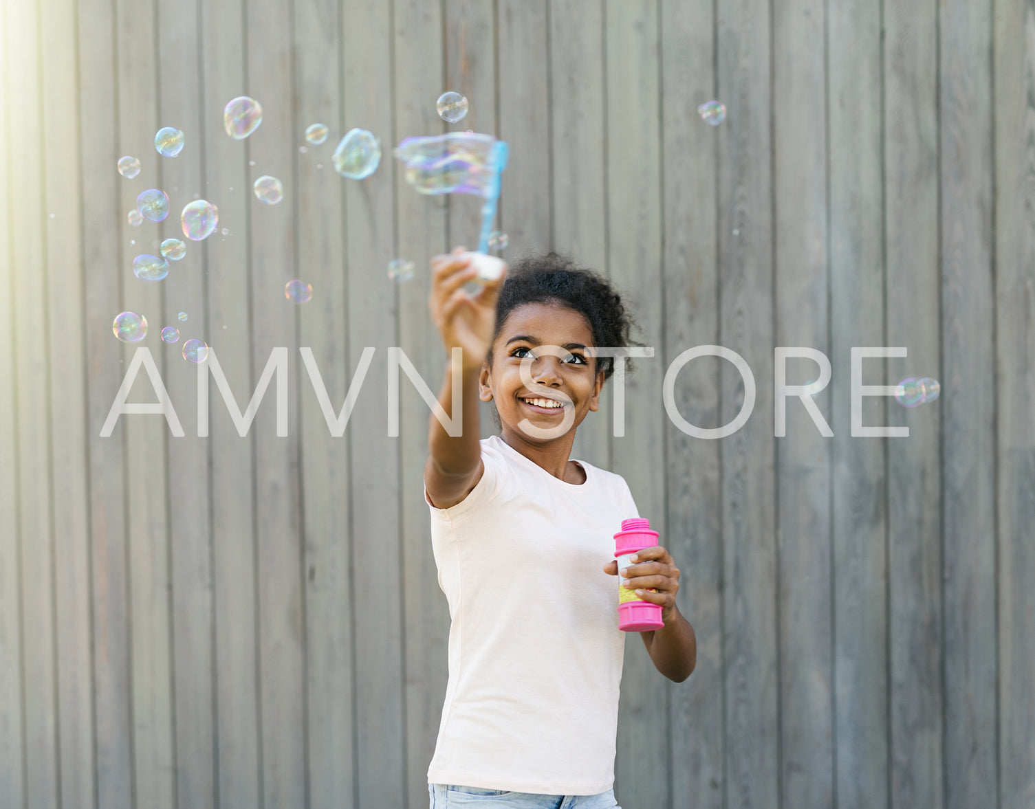 Happy girl in park making soap bubbles	