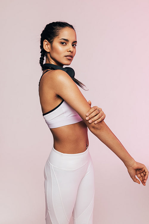 Side view of a young mixed race woman warming up her arm before exercises