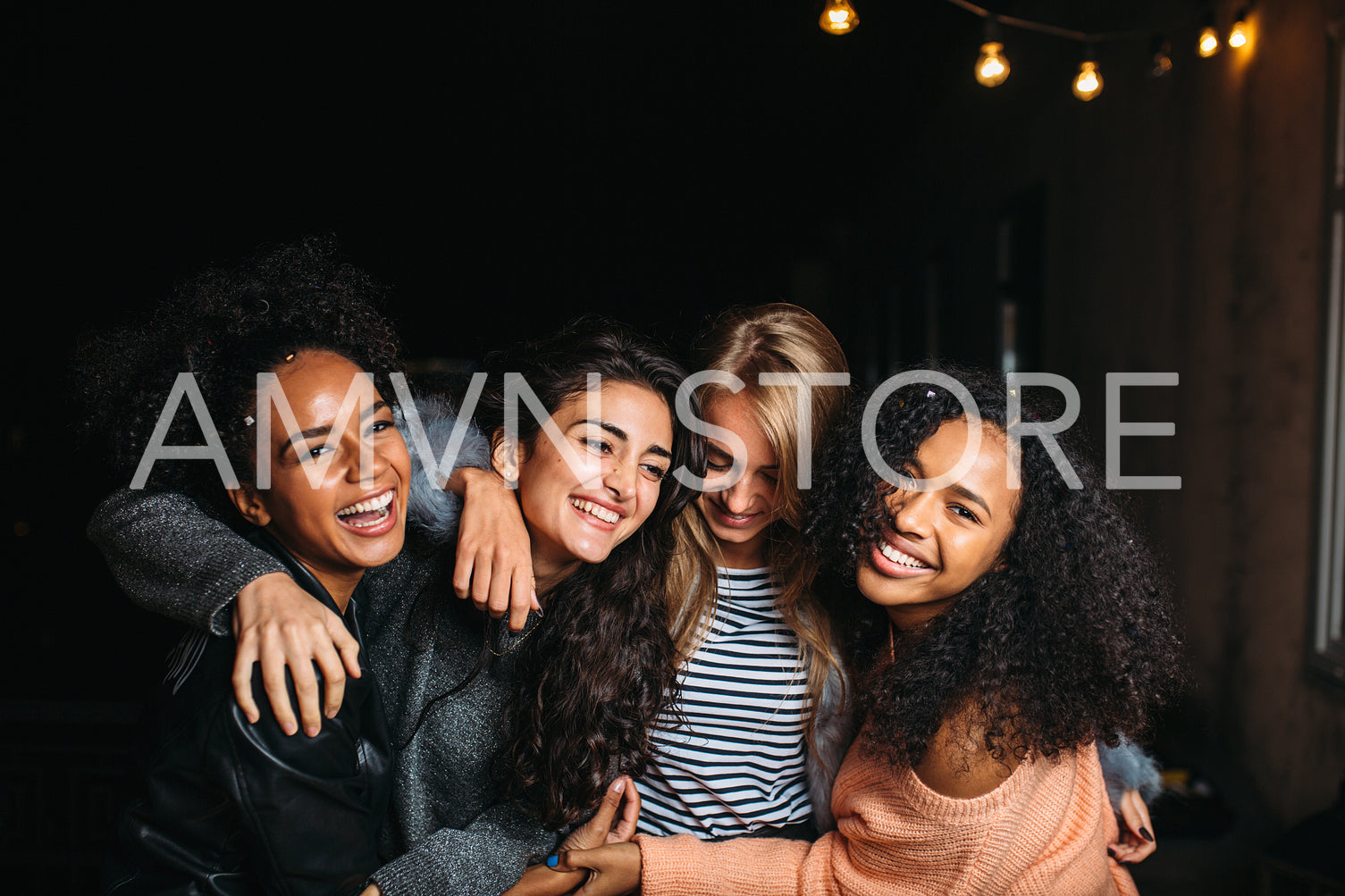 Four beautiful women looking at camera, standing outdoors at night	