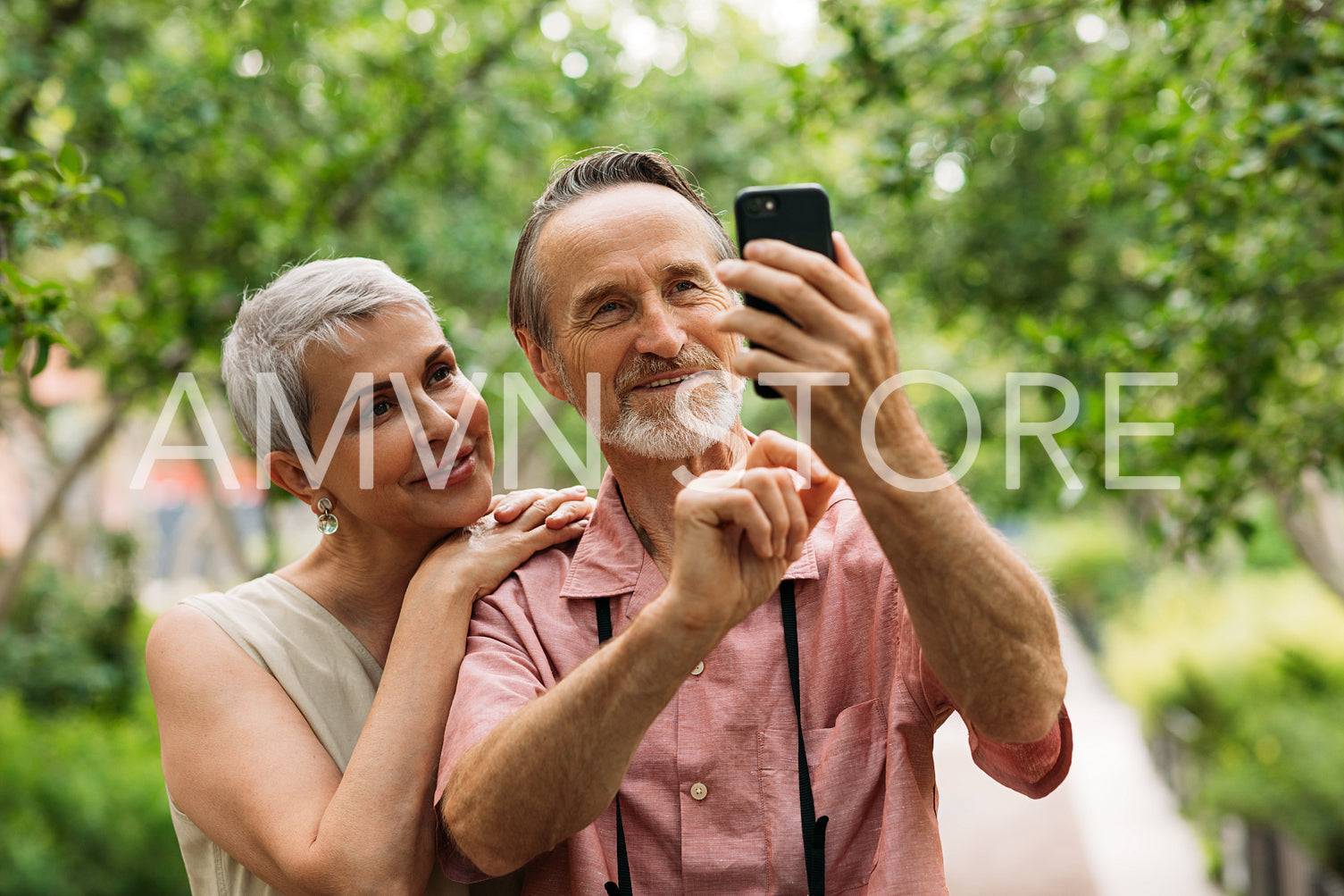 Aged smiling couple taking selfie outdoors in the park