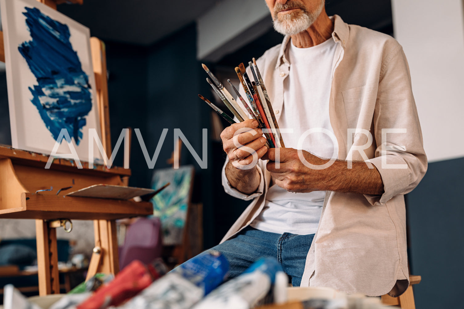 Man working as painter checking brushes before painting	