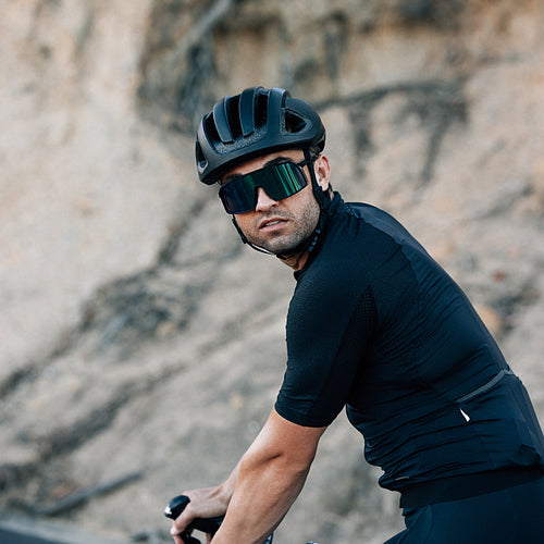 Portrait of a male cyclist in helmet and glasses outdoors looking at the camera