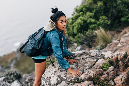 Young woman on a hike. Female hiker climbing up.