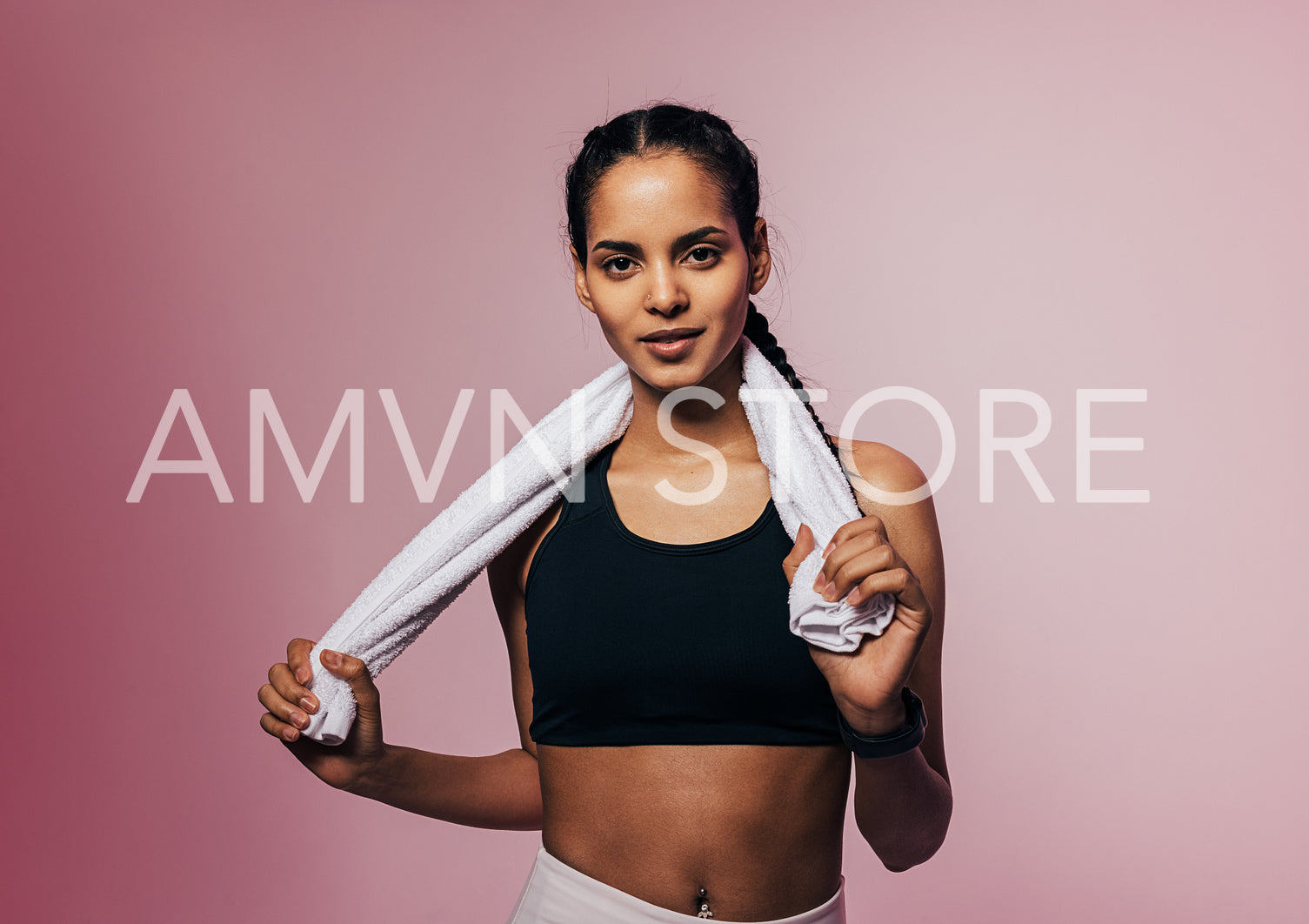 Portrait of a young sportswoman posing in studio with white towel