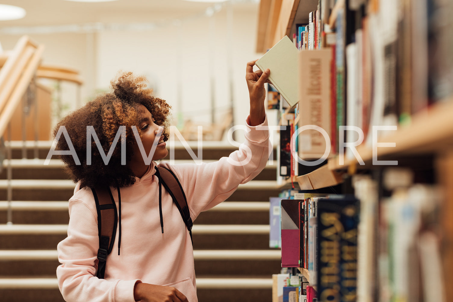 Girl taking a book from bookshelf in library