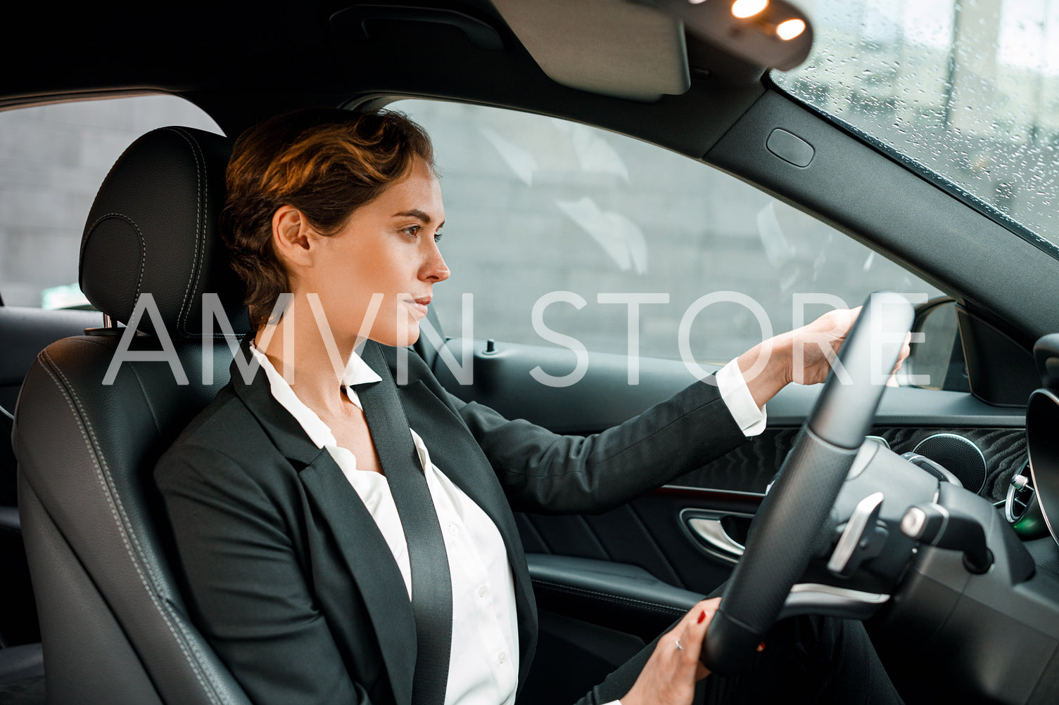 Businesswoman driving a car. Young female in formal wear holding a steering wheel.	