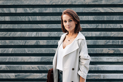 Confident middle-aged woman in casual clothes holding folder looking at camera