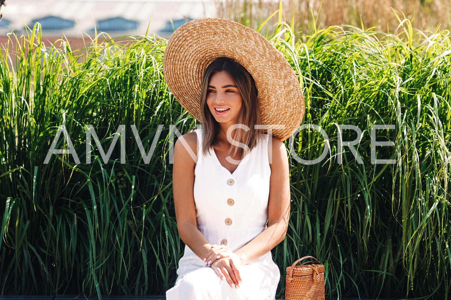 Young smiling woman sitting in the park and looking away