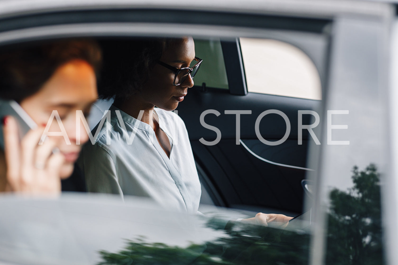 Two business colleagues working from the backseat of a taxi	