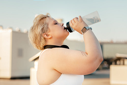 Side view of plus size woman taking a break during training