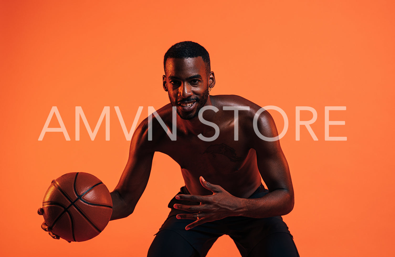 Bare-chested basketball player doing dribbling against an orange background