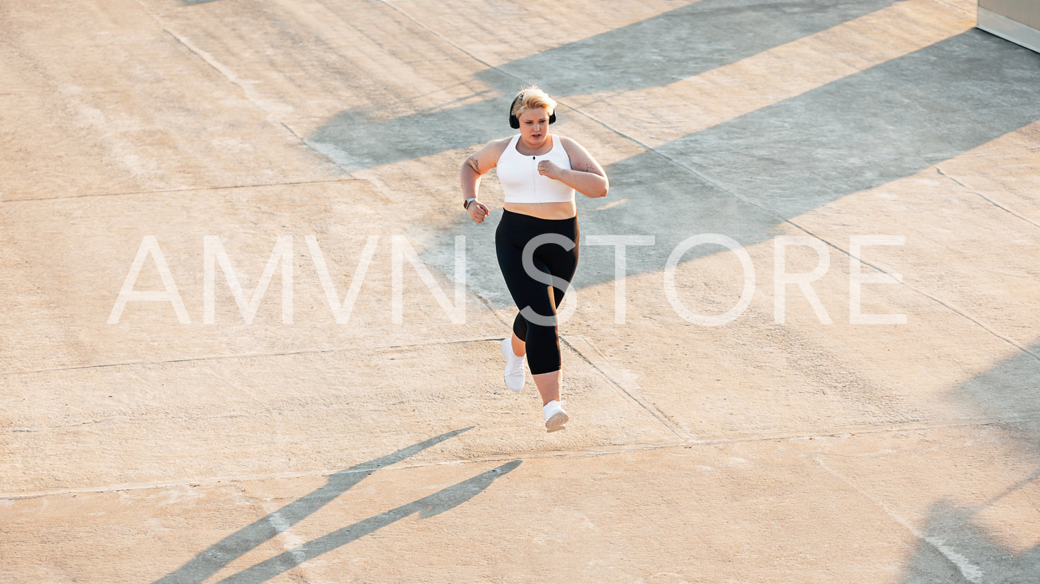 High angle view of plus size woman running outdoors. Young curvy female in sportswear jogging on roof.	High angle view of plus size woman running outdoors. Young curvy female in sportswear jogging on roof.	