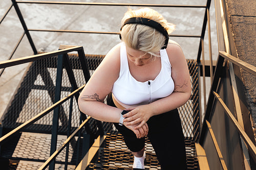 High angle view of a plus size woman standing on a staircase