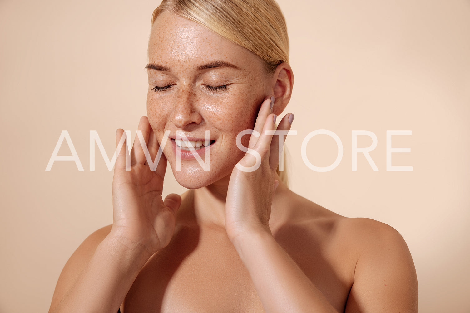 Young smiling woman massaging her face with fingers standing in