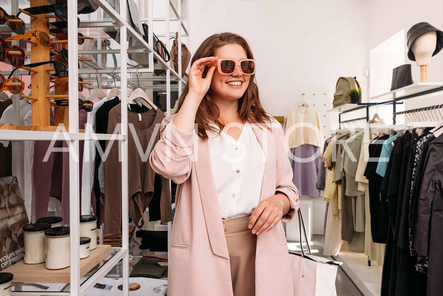 Happy plus size woman standing in small fashion store. Cheerful 