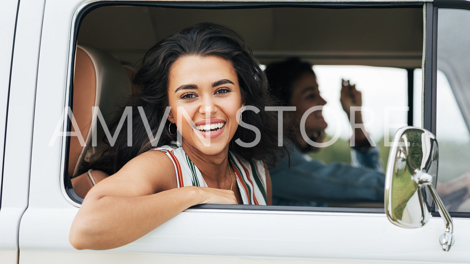 Attractive brunette woman looking outside the car window while traveling 