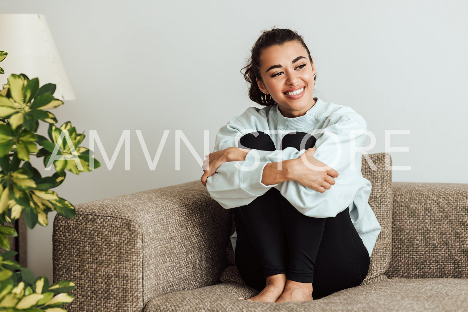 Beautiful brunette woman sitting on sofa	