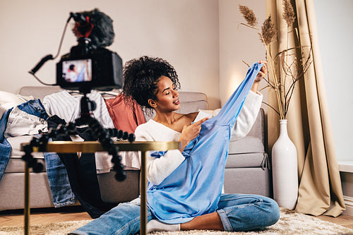 Fashion vlogger recoding video about casual shirt in living room