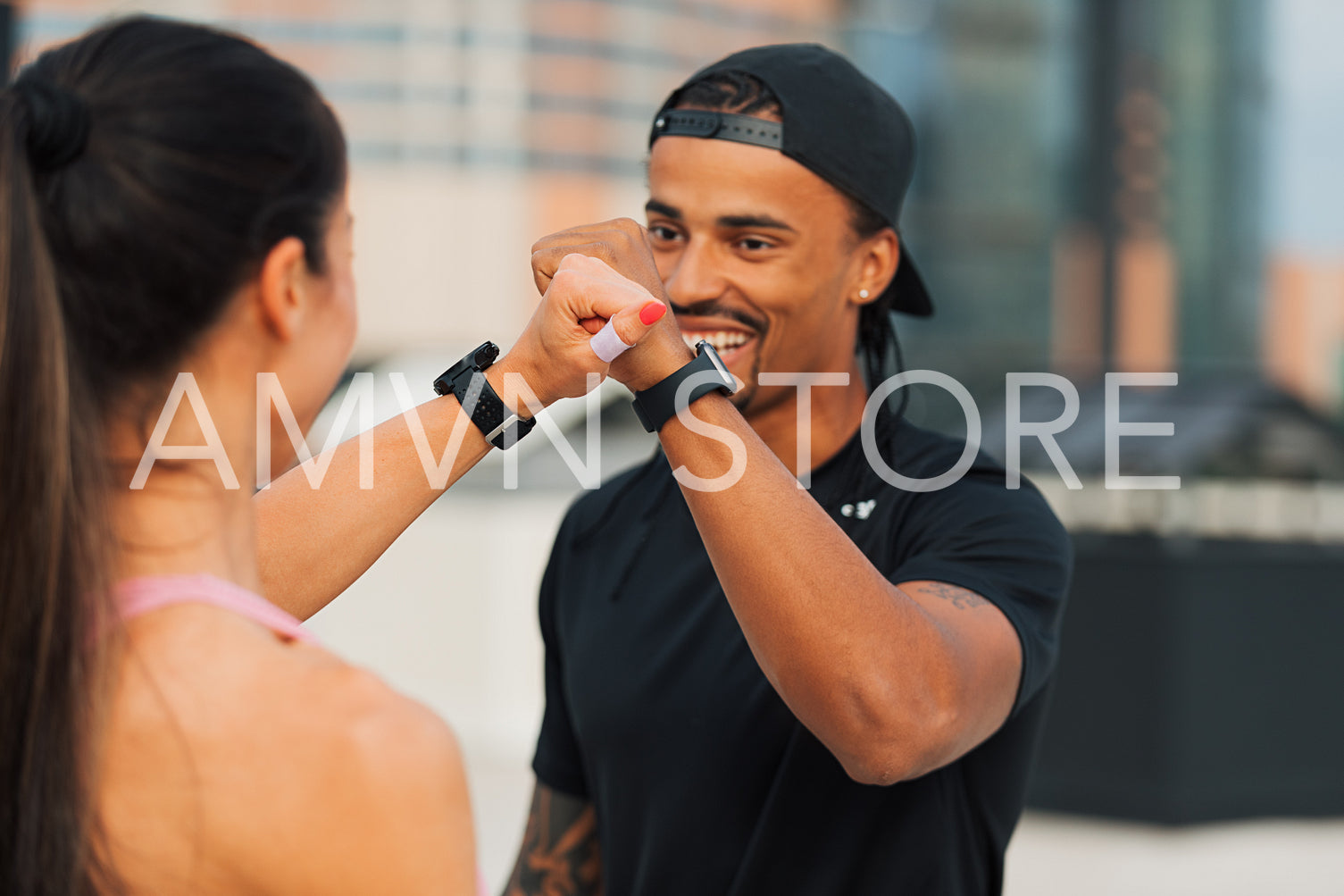 Fitness couple giving fist bump after training on the roof