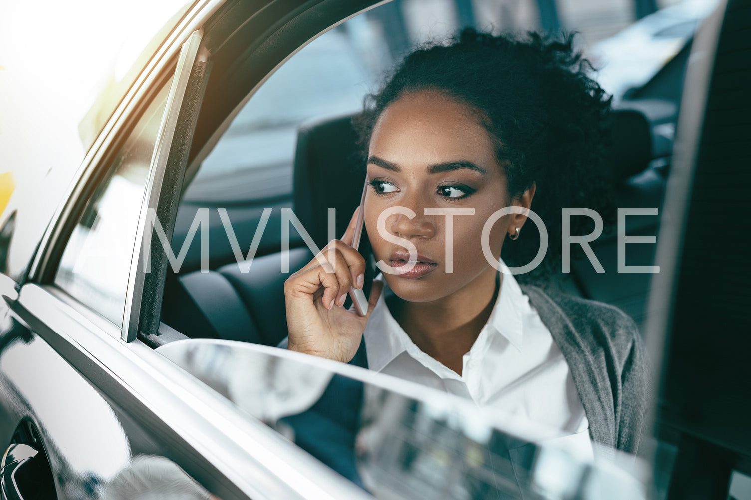 Female entrepreneur talking on mobile phone while sitting in taxi	