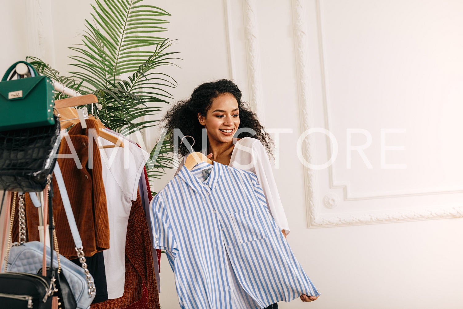 Woman trying on shirt. Beautiful vlogger posing with hanger.	
