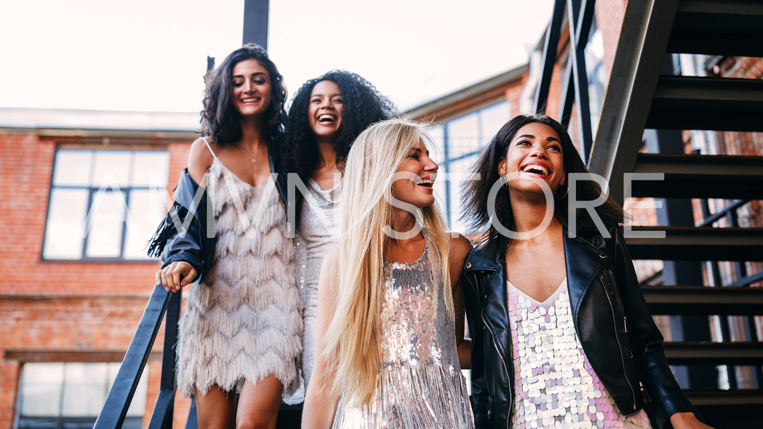 Happy women hugging each other while stepping down stairs	