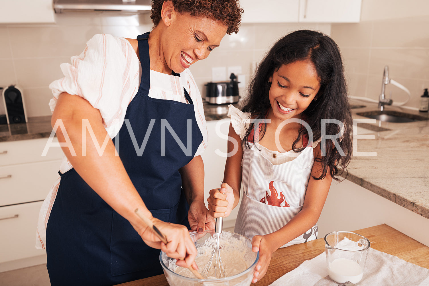 Smiling grandmother and granddaughter mixing dough in a bowl