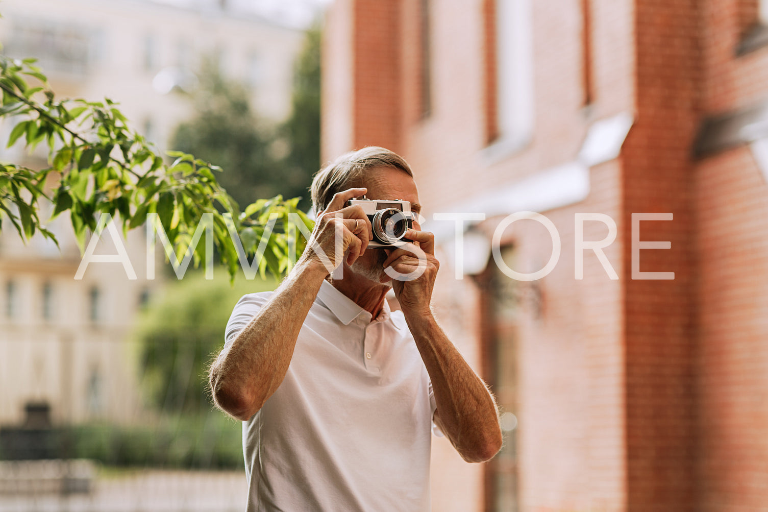 Senior tourist walking in the city and making photographs on a film camera	