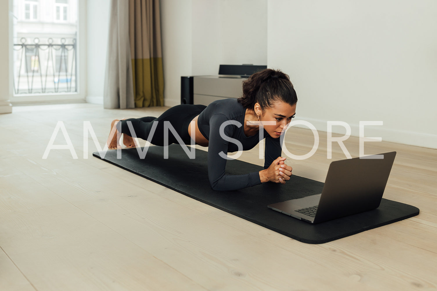 Young fit woman doing plank on mat at home	