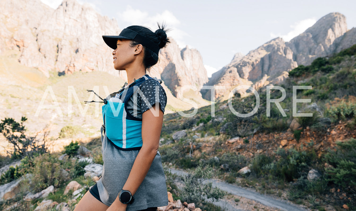 Woman in sports wear taking a break during hike in wild terrain looking on mountains