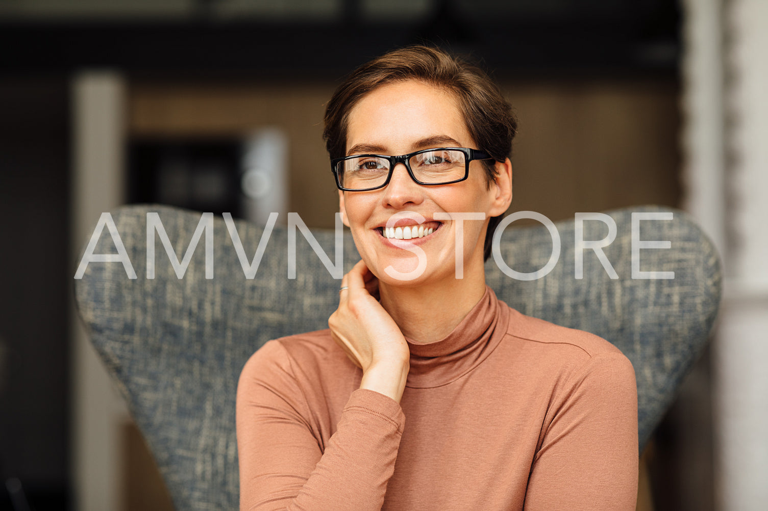 Close up portrait of a beautiful businesswoman sitting on an armchair in apartment	